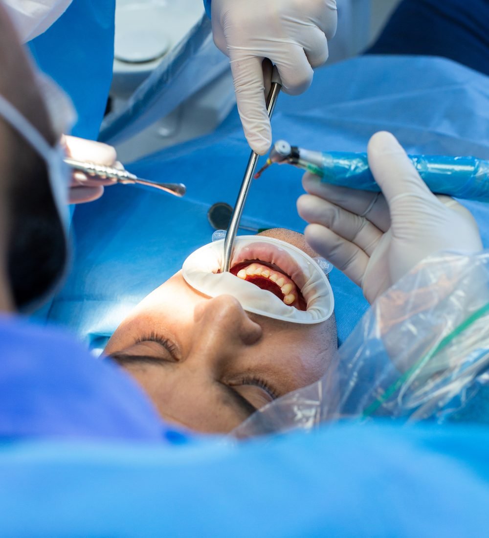 dentist and assistant with tool makes some manipulations in the patient's mouth